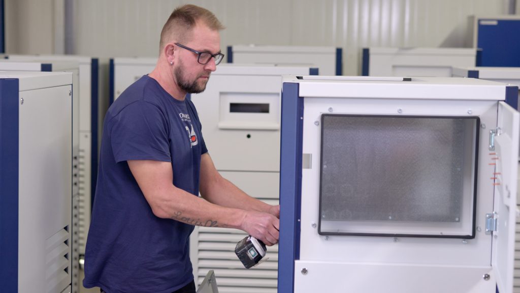 Mitarbeiter bei JORDAN in der Produktionshalle, er montiert Teile aus Blech